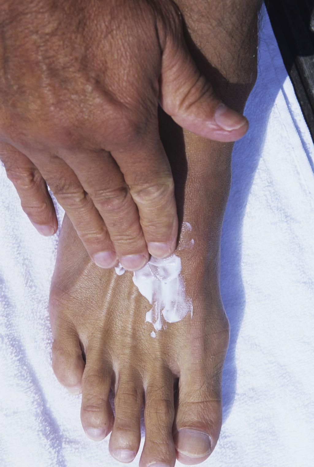 Hand rubbing lotion on foot