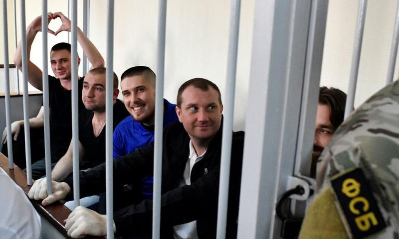 In the cramped courtroom, the sailors, who have described themselves as 'prisoners of war', were held in a metal-barred cage reserved for defendants