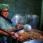 Women serve food at a soup kitchen which feeds at least 200 people hit hard by the economic crisis