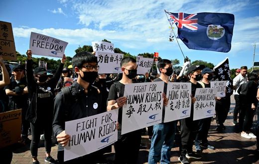 Supporters of the Hong Kong pro-democracy protesters hold placards during a demonstration as part of the global "anti-totalitarianism" movement in Sydney