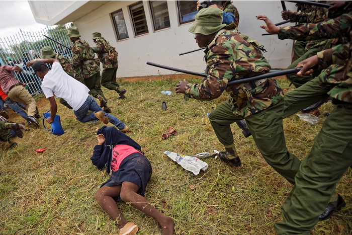 Supporters of President Uhuru Kenyatta engage in rock-throwing clashes with police at his inauguration ceremony after trying to storm through gates to get in and being tear-gassed, at Kasarani stadium in Nairobi, Kenya.