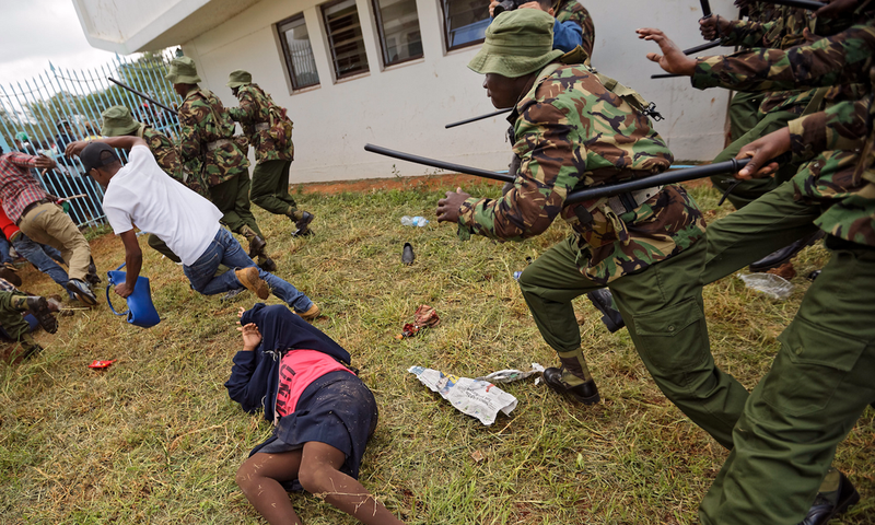 Supporters of President Uhuru Kenyatta engage in rock-throwing clashes with police at his inauguration ceremony after trying to storm through gates to get in and being tear-gassed, at Kasarani stadium in Nairobi, Kenya.