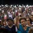 People hold up their phones during a prayer and candle vigil organized by the city, after a shooting left 20 people dead at the Cielo Vista Mall Wal-Mart in El Paso, Texas, on August 4, 2019