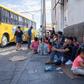 Migrants, mostly from Mexico, are pictured sitting on the ground waiting near the Paso del Norte Bridge at the Mexico-US border, in Ciudad Juarez, Mexico, on September 12, 2019.