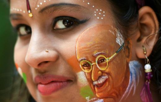 Britain will commission a commemorative coin to mark the 90th anniversary of the final visit by Indian independence hero Mahatma Gandhi; a girl poses for a picture, August 15, 2019, with her face painted depicting a portrait of Mahatma Gandhi