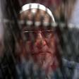 Egyptian Muslim Brotherhood Supreme Guide Mohamed Badie is seen behind bars during a hearing for him and other Brotherhood members on charges of espionage, as the country's crackdown on the Islamist group continues