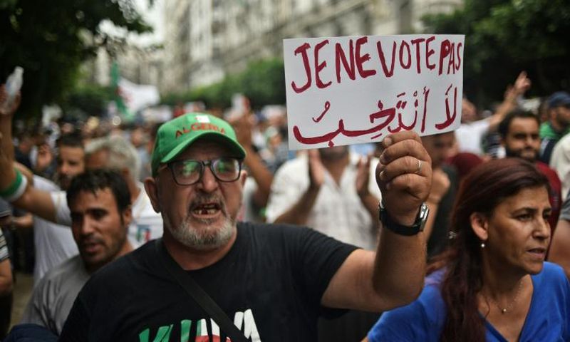 An Algerian protester holds a placard reading "I won't vote" during a demonstration against the ruling class in the capital Algiers on September 13, 2019, for the 30th consecutive Friday since the movement began