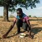 Leon Kufakunesu gathers jackalberry fruit onto a plate which his mother has resorted to serving the family as a midday meal