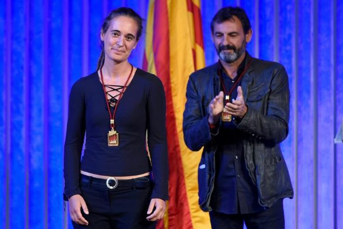 Migrant rescue ship captain Carola Rackete is given a medal from Catalonia's regional parliament alongside Proactiva Open Arms founder Oscar Camps