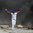 A demonstrator waves a Haitian flag during a protest against President Jovenel Moise on October 4, 2019 in Port-au-Prince