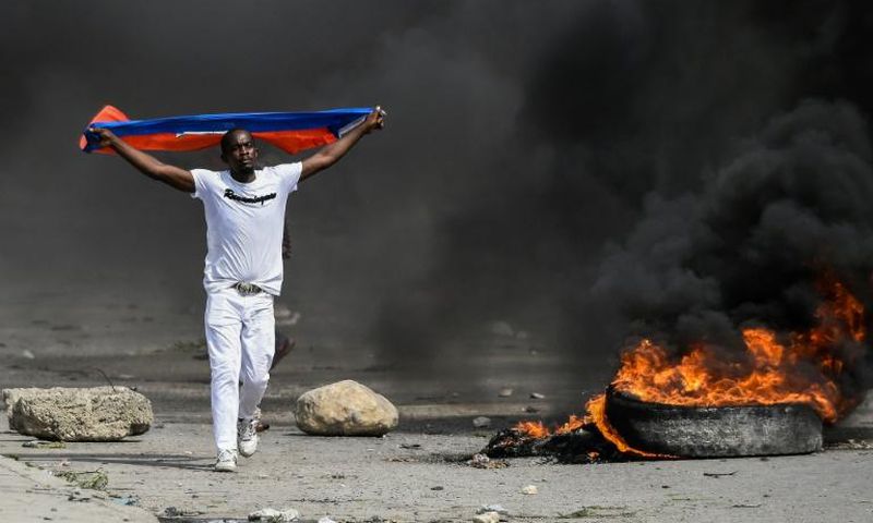 A demonstrator waves a Haitian flag during a protest against President Jovenel Moise on October 4, 2019 in Port-au-Prince
