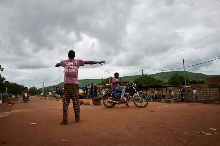 A Malian activist directs traffic on August 27, with the main road between the capital of Bamako and the western city of Kayes closed due to protest