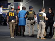 FBI agents holding one of the suspect arrested in the crack down on internet fraud