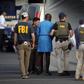FBI agents holding one of the suspect arrested in the crack down on internet fraud