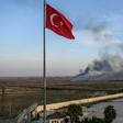 Smoke rises from the Syrian town of Tal Abyad, in a picture taken from the Turkish side of the border where the Turkish flag is seen in Akcakale on October 10, 2019, on the second day of Turkey's military operation against Kurdish forces