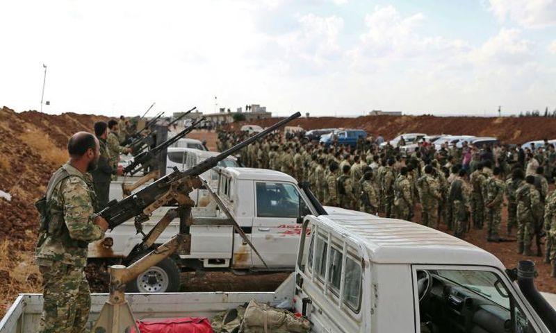Turkish-backed Syrian rebel fighters gather near the Syrian-Turkish border as Ankara threatened an offensive against Kurdish militias it considers terrorists