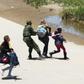 Members of Mexico's National Guard prevent a mother and daughter from crossing the border into the US from Juarez, Mexico