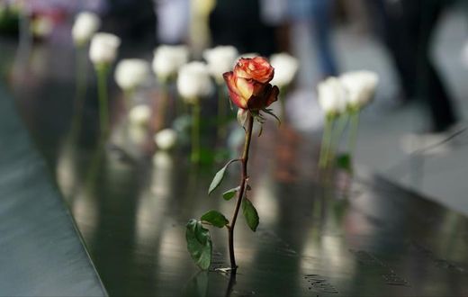People leave flowers during the September 11 Commemoration Ceremony at the 9/11 Memorial at the World Trade Center on September 11, 2019,in New York.