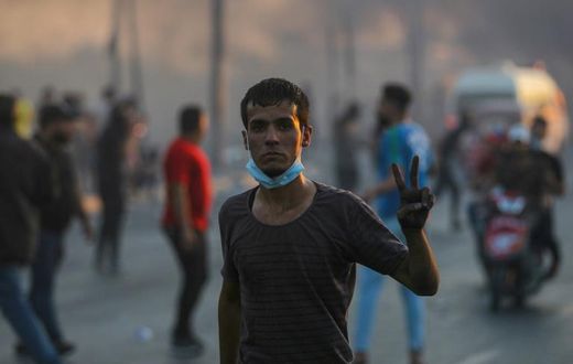 An Iraqi demonstrator flashes the victory sign during a demonstration in Baghdad Saturday