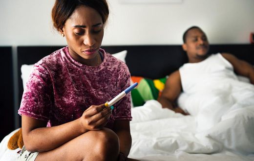 Woman holding pregnancy test(Rawpixel)