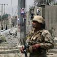 An Afghan security personnel stands guard at the site where a Taliban car bomb detonated at the entrance of a police station in Kabul on August 7