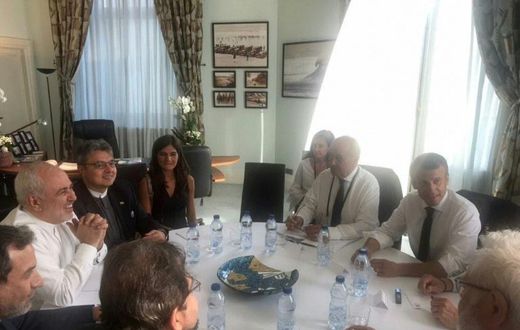 Mohammad Javad Zarif smiling broadly during talks with President Emmanuel Macron and other French officials