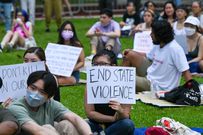 Attendees at a public rally hold signs during a protest against the death penalty at Speakers' Corner in Singapore on April 3, 2022