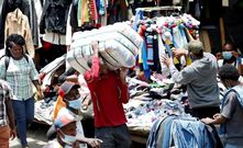 A man carrying a bale of thrift clothes [Image Credit: The Eastleigh Voice]