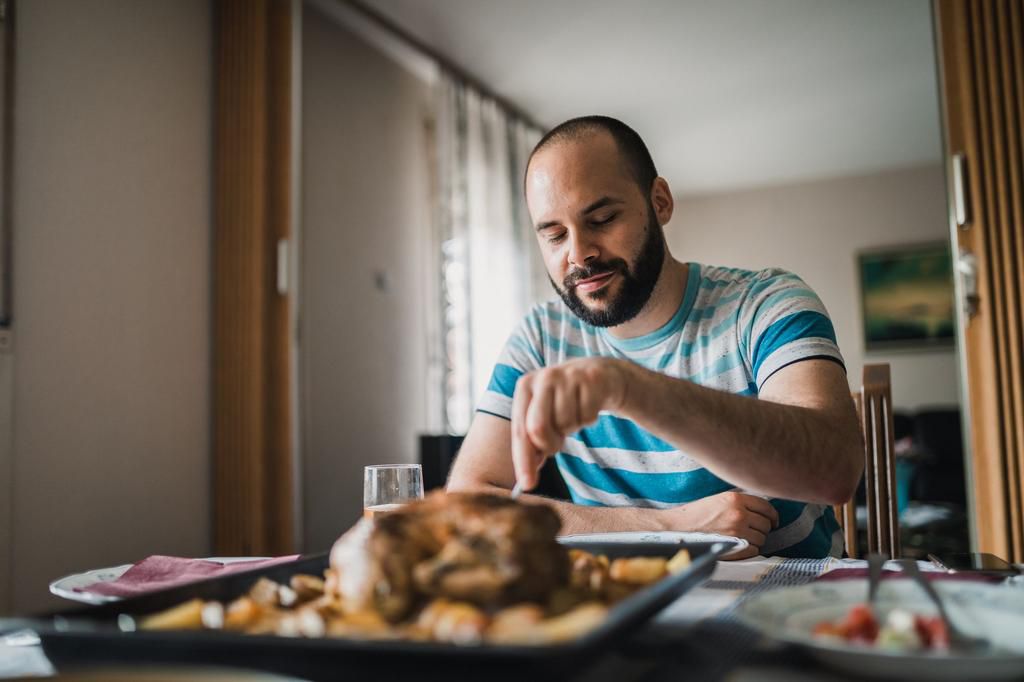 Handsome man sitting at the table and eating lunch