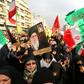 Iranian pro-government demonstrators raise national flags and pictures of the Islamic republic's supreme leader, Ayatollah Ali Khamenei, as they gather in the capital Tehran's central Enghelab Square