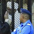 Sudan's deposed president Omar al-Bashir sits in a defendant's cage during his corruption trial in Khartoum on December 14