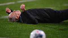 Freiburg head coach Christian Streich lies on the pitch after being barged by Frankfurt captain David Abraham on Sunday.