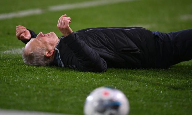 Freiburg head coach Christian Streich lies on the pitch after being barged by Frankfurt captain David Abraham on Sunday.