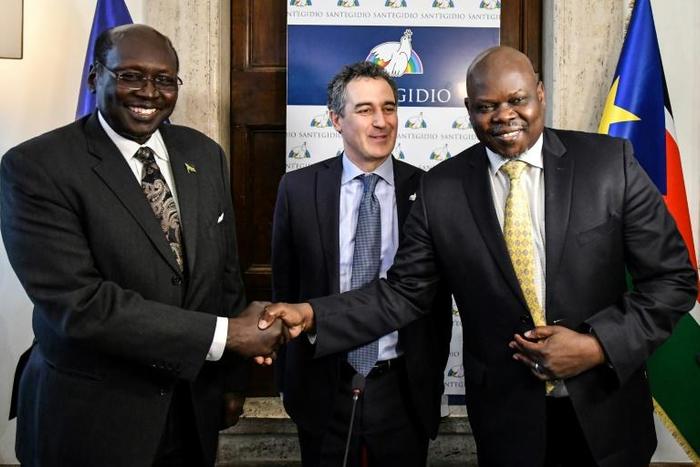 South Sudanese  presidential advisor Barnaba Marial Benjamin (L) shakes hands with the co-founder of South Sudan Reborn, Pagan Amum (R) as the Community of Sant'Egidio's International Relations Office Paolo Impagliazzo (C) looks on