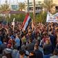 Iraqi followers of influential cleric Moqtada Sadr (with batons) clash with protesters as they raid an anti-government protest camp in the central holy city of Najaf on Wednesday
