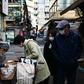 A woman in a face mask buys food from a vendor in Tokyo
