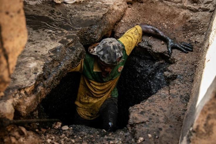 Return to light: Wendgoundin Sawadogo climbs back up after emptying a latrine in Ouagadougou