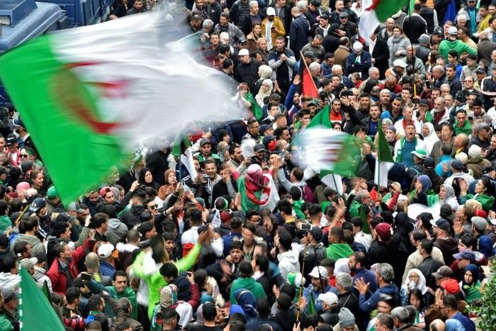 Algerian protesters wave national flags during an anti-government demonstration in the capital Algiers