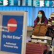 Passengers wear masks to protect against the spread of the Coronavirus as they arrive at the Los Angeles International Airport