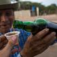 Venezuelan distiller Dolores Gimenez, 84, serves a cup of cocuy, a traditional liquor, at the Coari craft distillery in Bobare