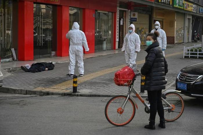 AFP reporters witness police and medics in protective suits dealing with a dead body in Wuhan