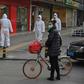 AFP reporters witness police and medics in protective suits dealing with a dead body in Wuhan