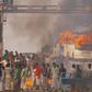 Protesters block a road after setting buses on fire during a demonstration against the Citizenship Amendment Bill in Howrah, on the outskirts of Kolkata