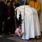 Pope Francis (R) blesses a toddler during an audience with refugees who arrived in Italy from the Greek island of Lesbos