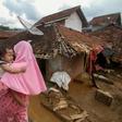 Villagers walk past homes damaged by flooding in Lebak, neighbouring Jakarta