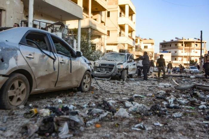 Damaged cars line a street following an air strike in Maarat Misrin on Tuesday
