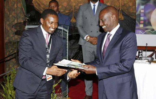 File image of Mwangi Kiunjuri receiving a report from DP Ruto during the opening of the comprehensive agriculture development programme at Safari Park hotel in Nairobi on June 12, 2019.