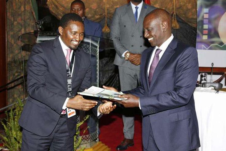 File image of Mwangi Kiunjuri receiving a report from DP Ruto during the opening of the comprehensive agriculture development programme at Safari Park hotel in Nairobi on June 12, 2019.