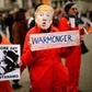 A protester holds up a placard, dressed as US President Donald Trump in Trafalgar Square during a demonstration against the threat of war on Iran, in central London on January 11, 2020