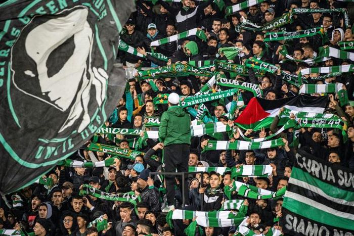 Supporters of Raja Club Athletic chant slogans and wave flags at a Moroccan football match between Raja and Mouloudia Oujda in January